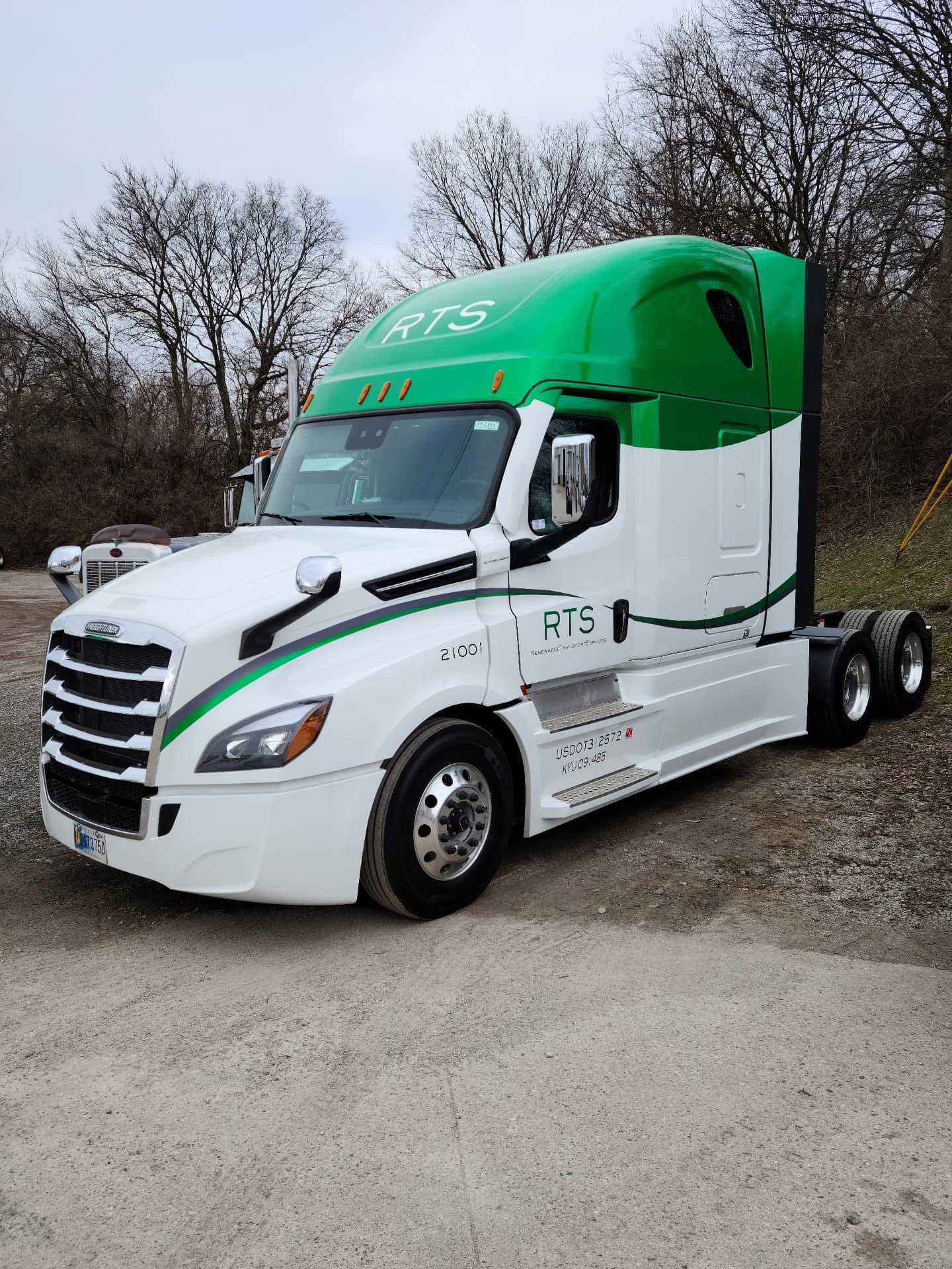 RTS green and white Freightliner Cascadia sleeper parked outdoors
